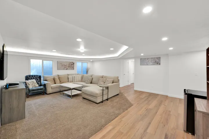Recessed lighting and accent lighting highlight a spacious room with light wood-finish flooring