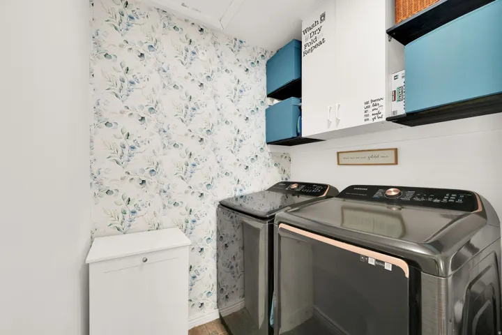 Built-in wall cabinetry, integrated dark shelving, and decorative botanical wallpaper