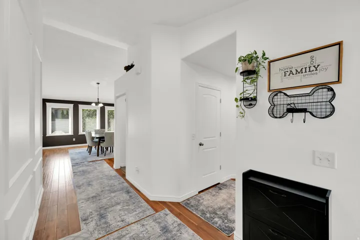Hardwood-style flooring throughout the entry, crisp white walls, and a recessed archway