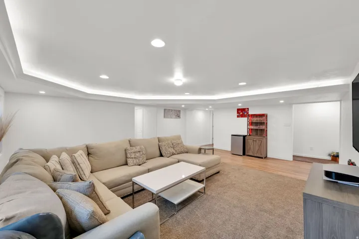 Recessed lighting, crown molding with accent lighting, wall-to-wall carpeting, wood-finish flooring, and built-in cabinetry
