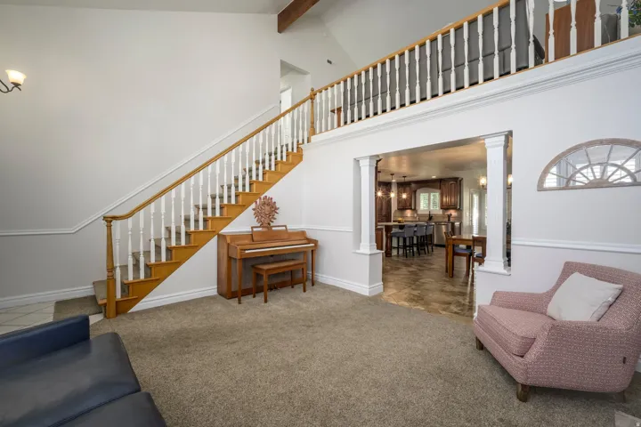Two-story entry with an open staircase, wood handrail, and carpeted treads
