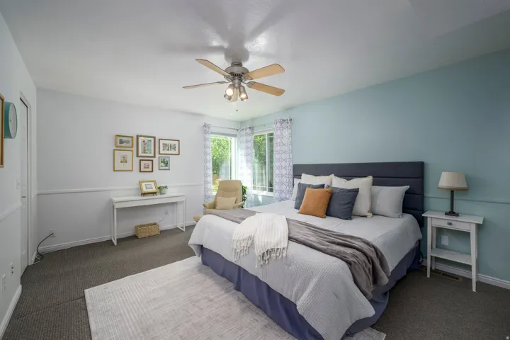 Recessed window with natural light, integrated ceiling fan, wainscoting, and carpeted flooring