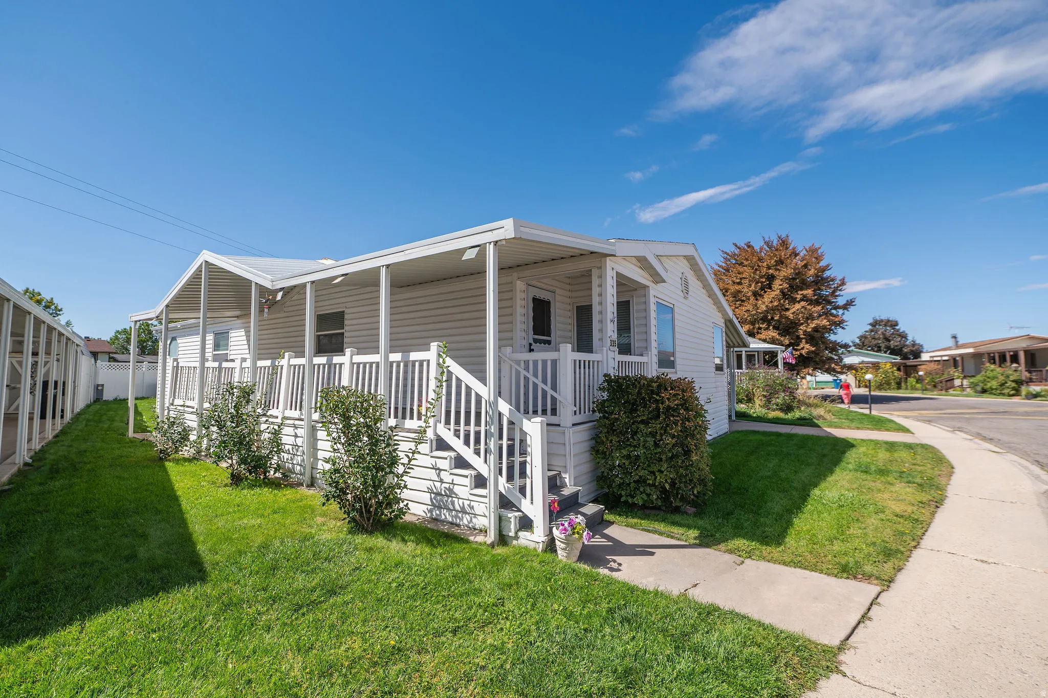 White exterior siding with a covered porch and railing system