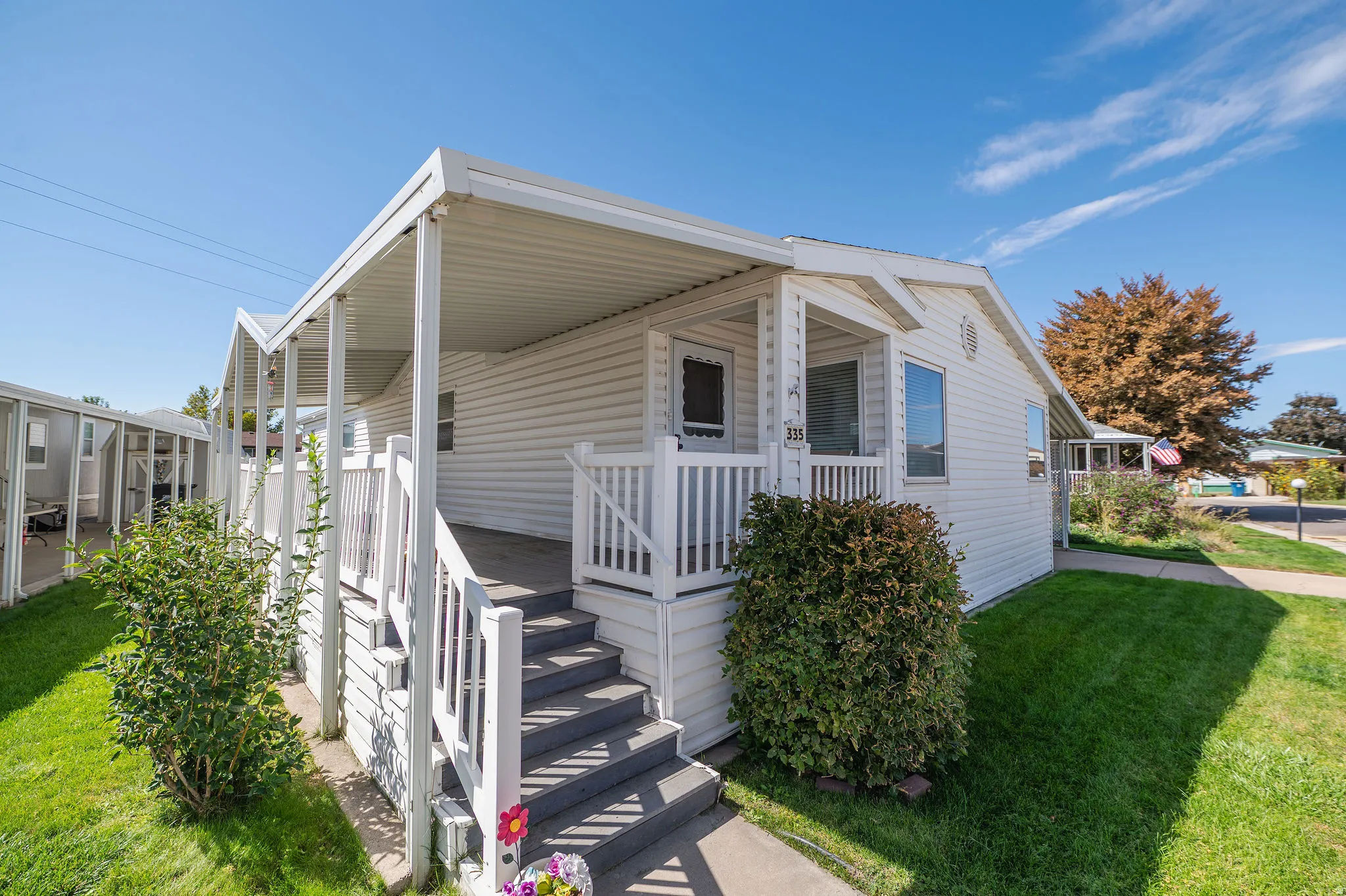 White siding exterior with a covered porch and railing