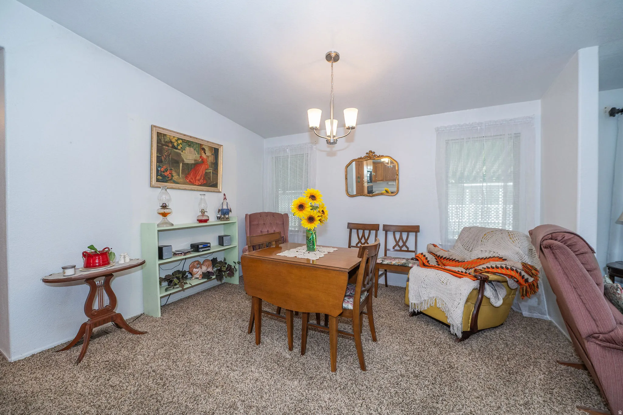 Carpeted flooring, white walls, and a chandelier with glass shades