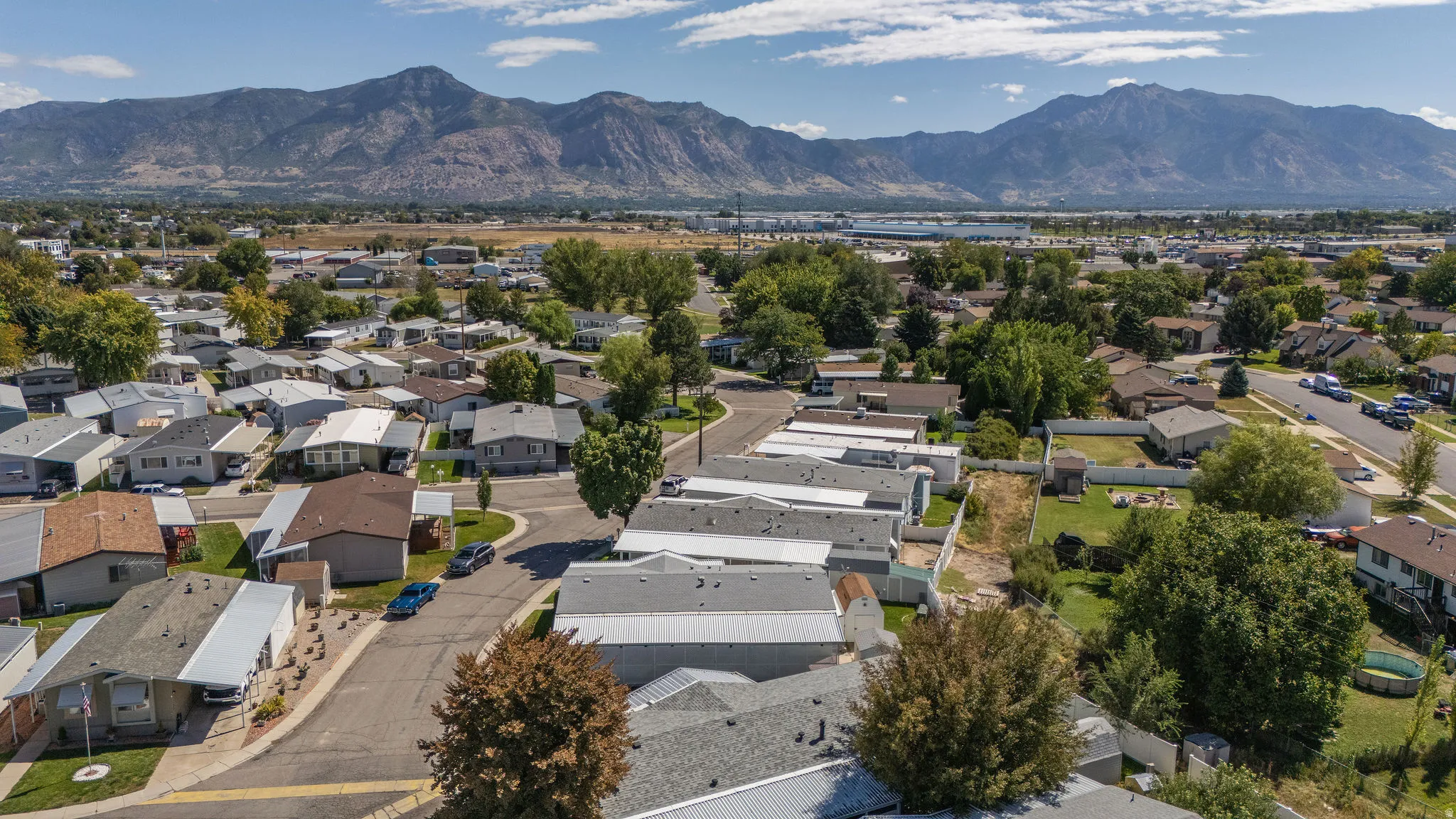 Aerial community perspective featuring a mountain backdrop, residential properties, and paved streets