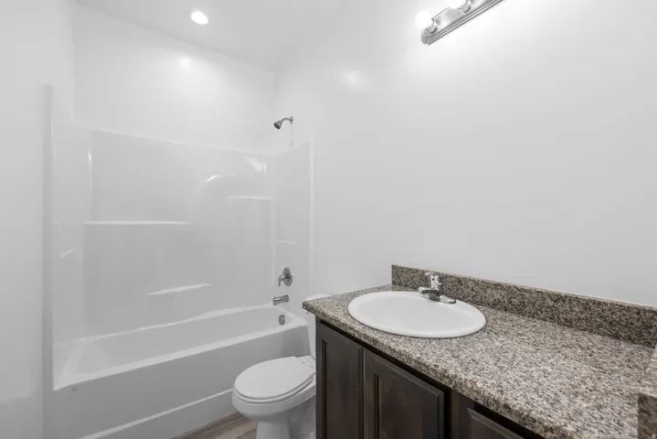 White acrylic tub and shower combination with chrome fixtures