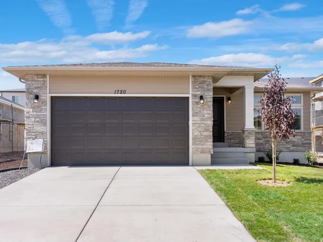 Single-story residence featuring stone accents, a concrete driveway, an integrated garage, and a covered entry with a white column