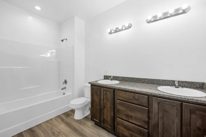 Dual vanity with dark wood-finish cabinetry and light-toned countertop, complete with two integrated sinks