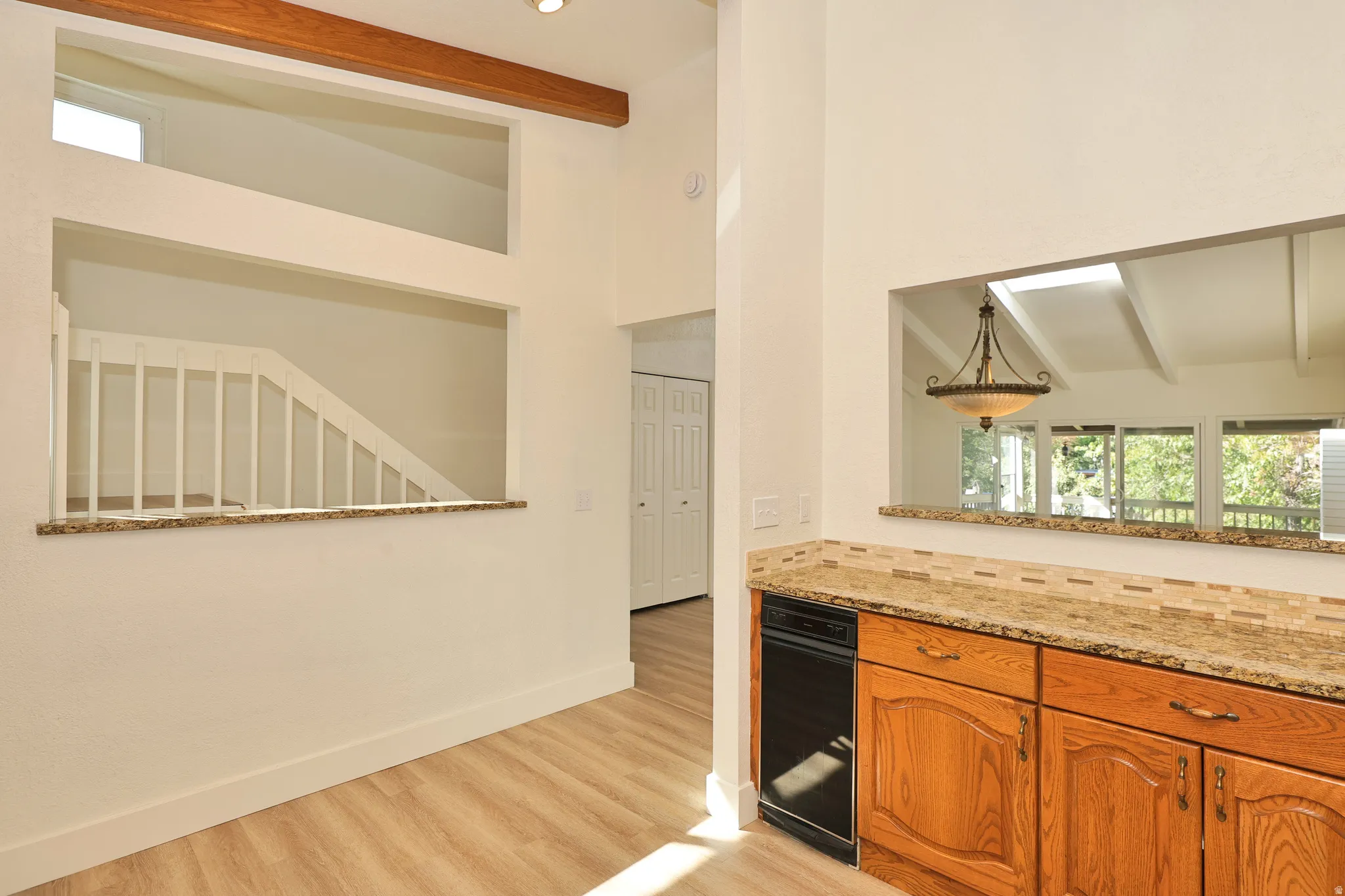 Wood-finish flooring with a high vaulted ceiling and exposed wooden beam