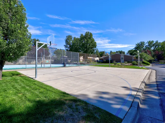 Recreational court featuring a basketball hoop and paved surface