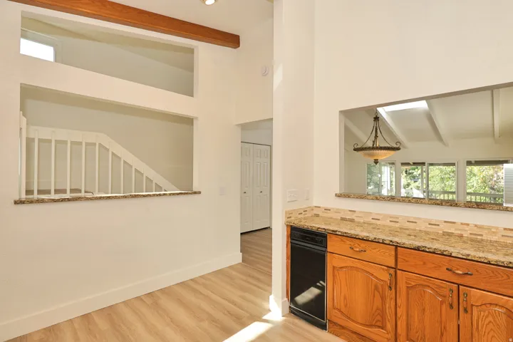 Wood-finish flooring with a high vaulted ceiling and exposed wooden beam