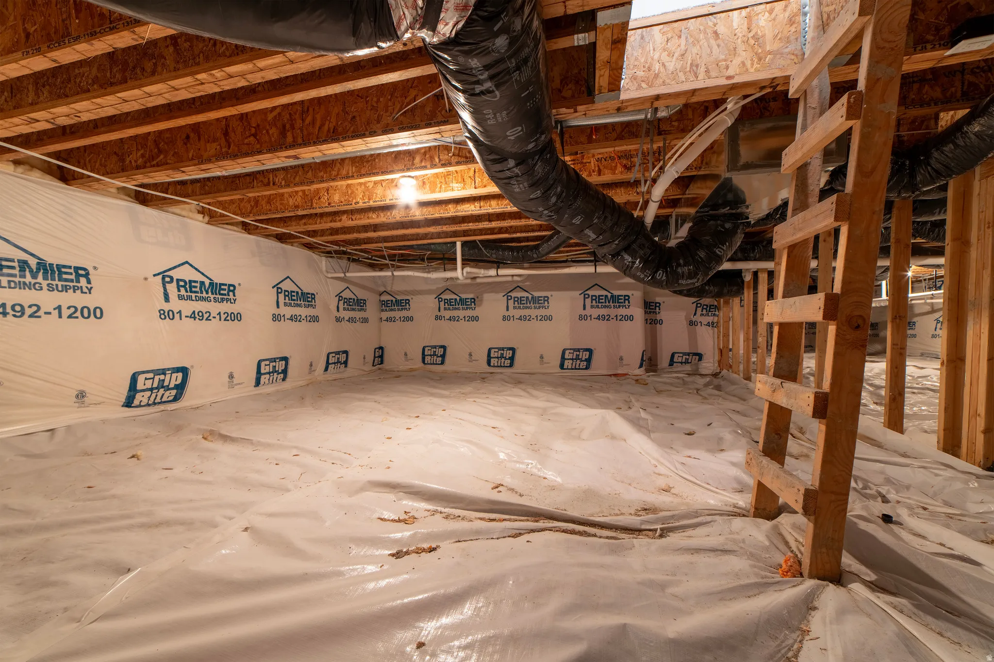 Encapsulated crawl space with exposed wood joists and subflooring
