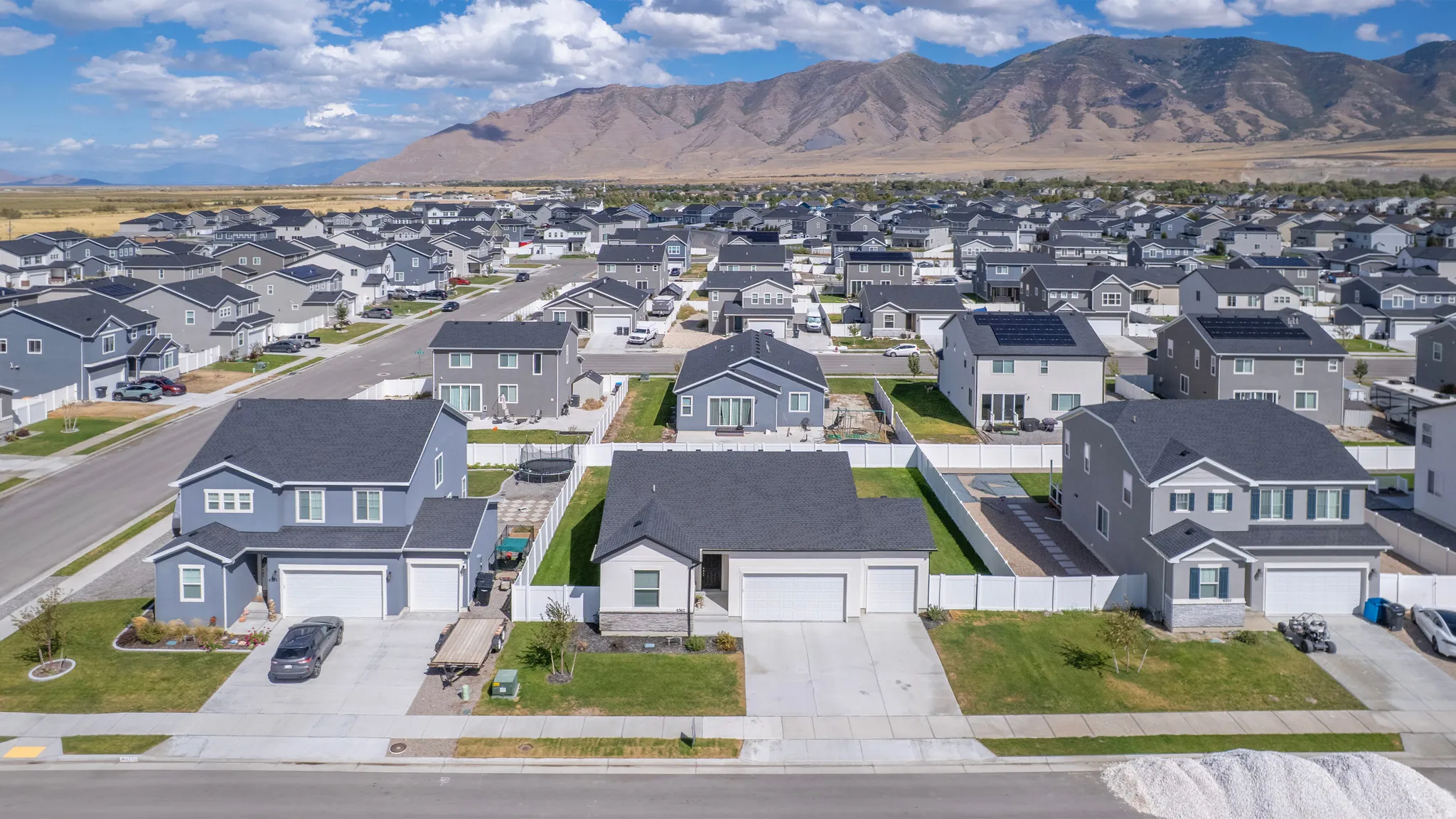 Expansive residential development featuring a mountain backdrop, uniform architectural styles, and established streetscapes