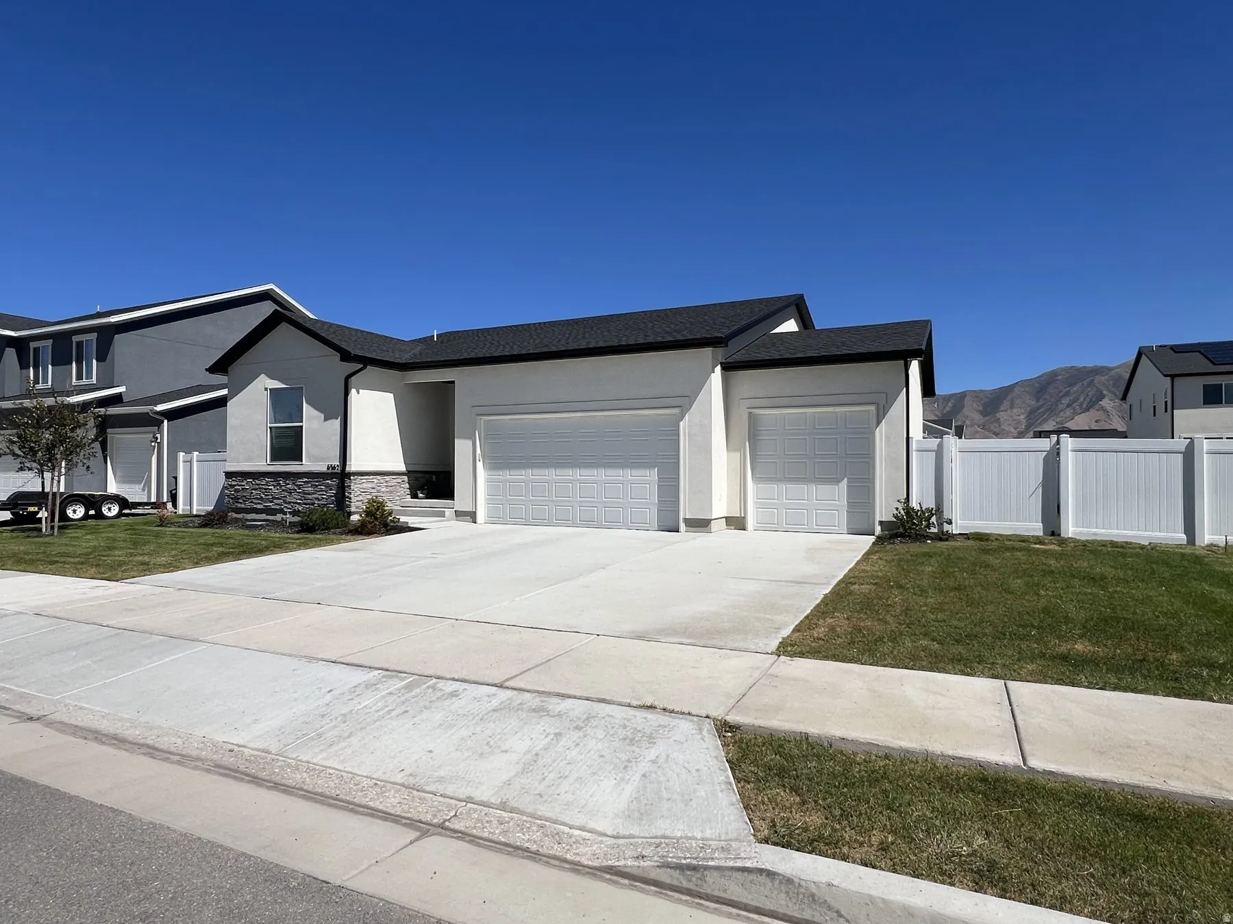 Single-story residence featuring a two-car garage, an additional single-car garage, and a concrete driveway