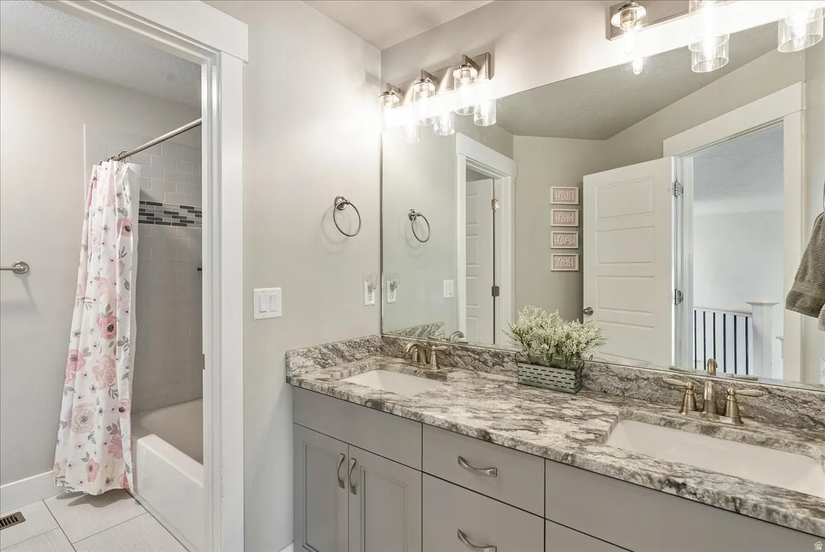 Dual vanity with undermount sinks, stone-finish countertop, and brushed nickel fixtures