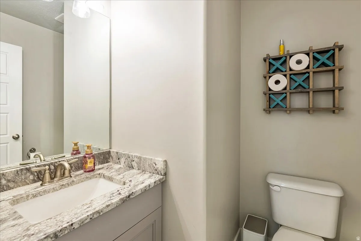 Half Bath-Vanity with a rectangular undermount sink, a two-handle faucet, and a stone-finish countertop