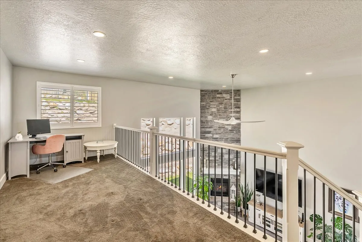 Upstairs Carpeted loft space with recessed lighting and windows featuring white plantation shutters