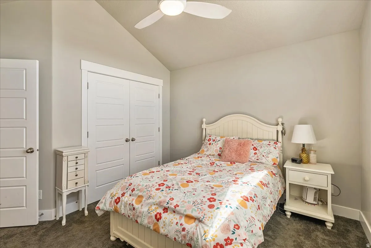Angled ceiling, ceiling fan, carpet flooring, white paneled doors