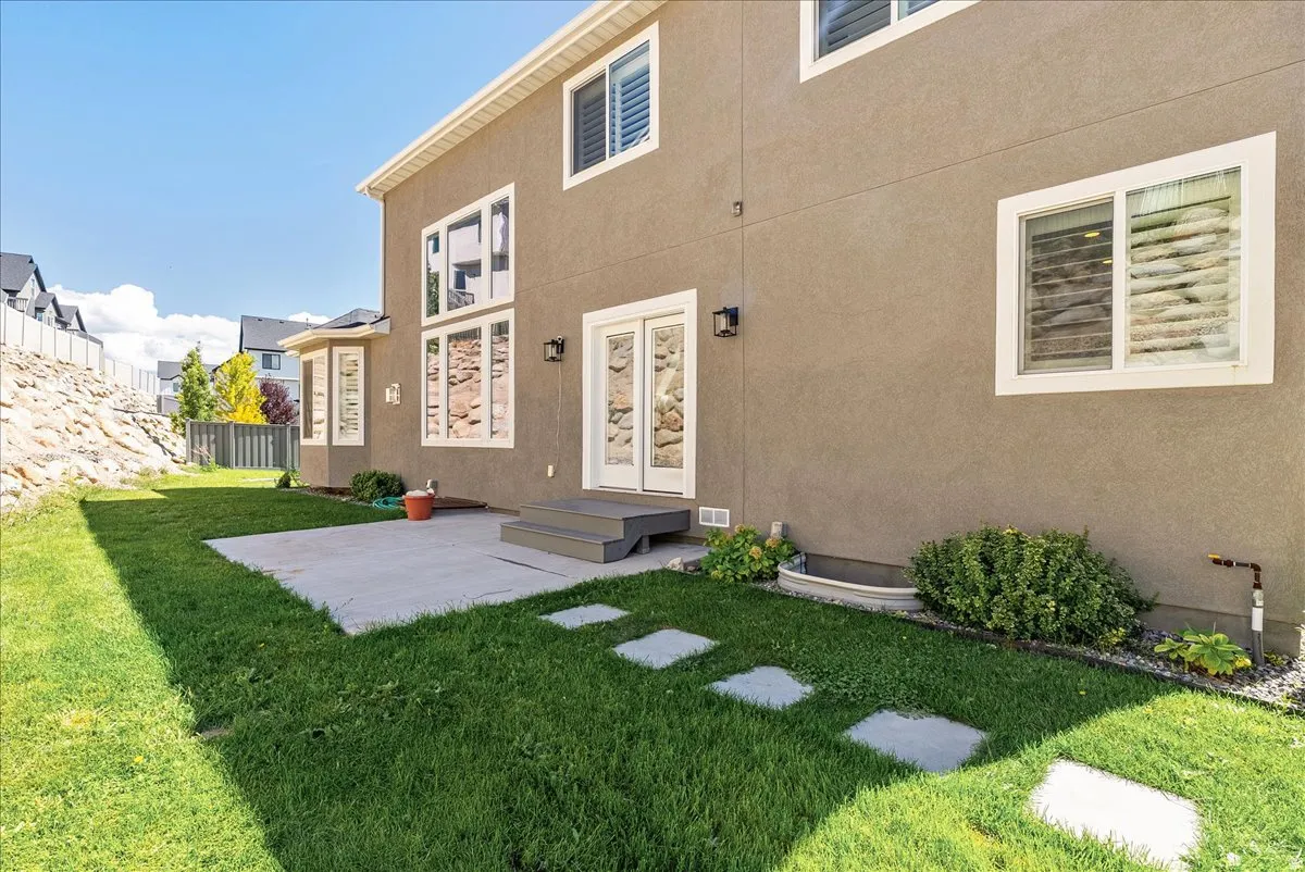 Stucco exterior with multiple windows, bay window, and double glass doors