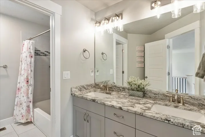 Dual vanity with undermount sinks, stone-finish countertop, and brushed nickel fixtures