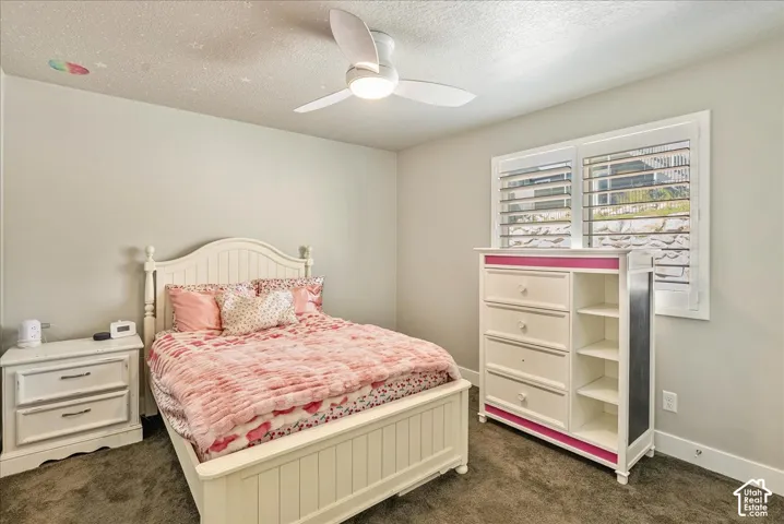 Recessed window with white plantation shutters, white ceiling fan with integrated lighting, and carpeted flooring