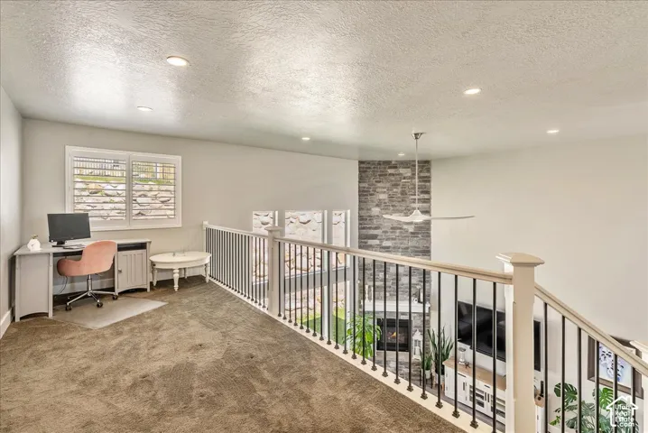 Upstairs Carpeted loft space with recessed lighting and windows featuring white plantation shutters