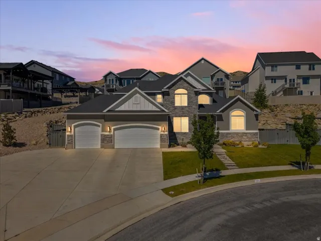 Two-story residence featuring a stone and stucco facade, an attached two-car garage, and a concrete driveway