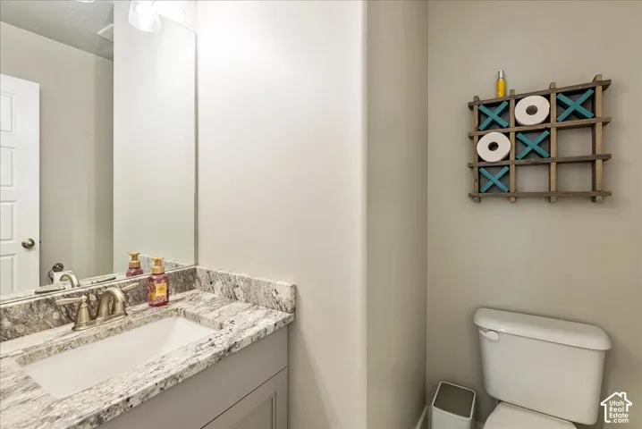 Half Bath-Vanity with a rectangular undermount sink, a two-handle faucet, and a stone-finish countertop