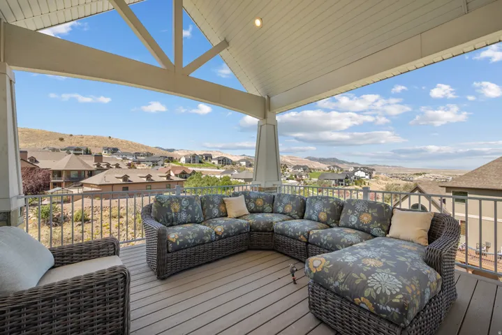 Covered outdoor deck with a vaulted ceiling, exposed trusses, and recessed lighting