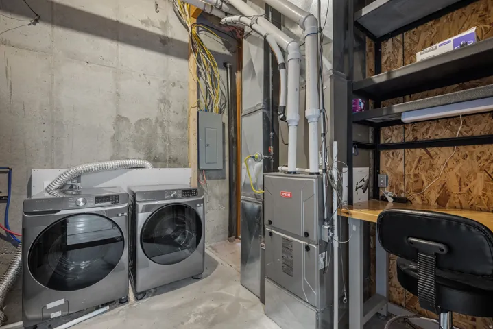 Laundry area with a washer and dryer, furnace, electrical panel, and built-in shelving