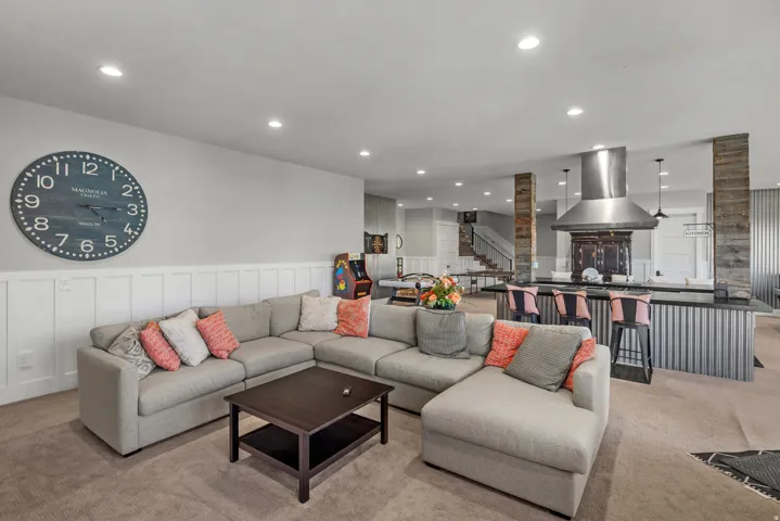 Recessed lighting, wainscoting, integrated kitchen island, stainless steel range hood, and wood-paneled structural columns