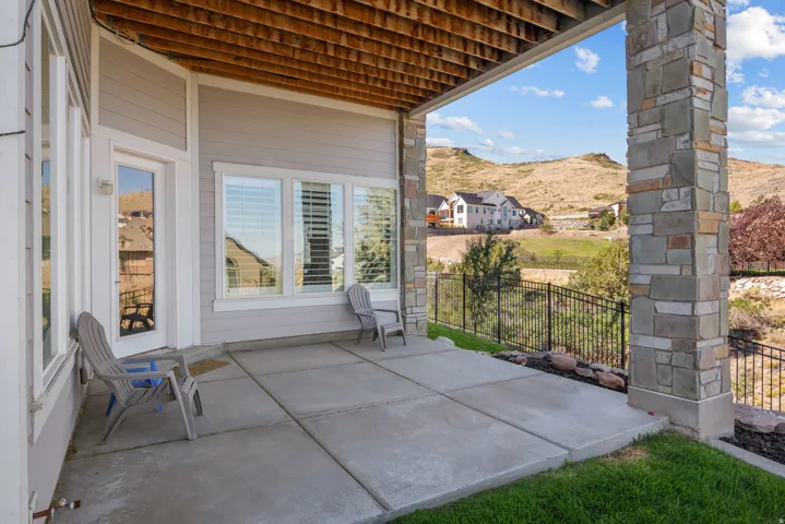 Covered concrete patio with a stone-clad support column
