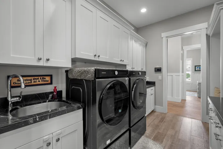 White shaker cabinetry and a dark stone-finish countertop with an integrated sink