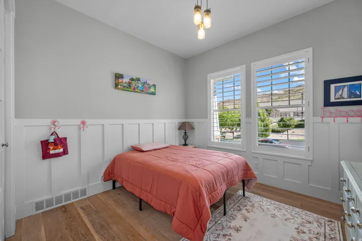 Wood-finish flooring with white wainscoting and light gray walls