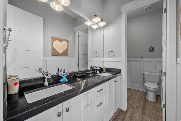 Double vanity with dark stone countertop, undermount sinks, and chrome fixtures