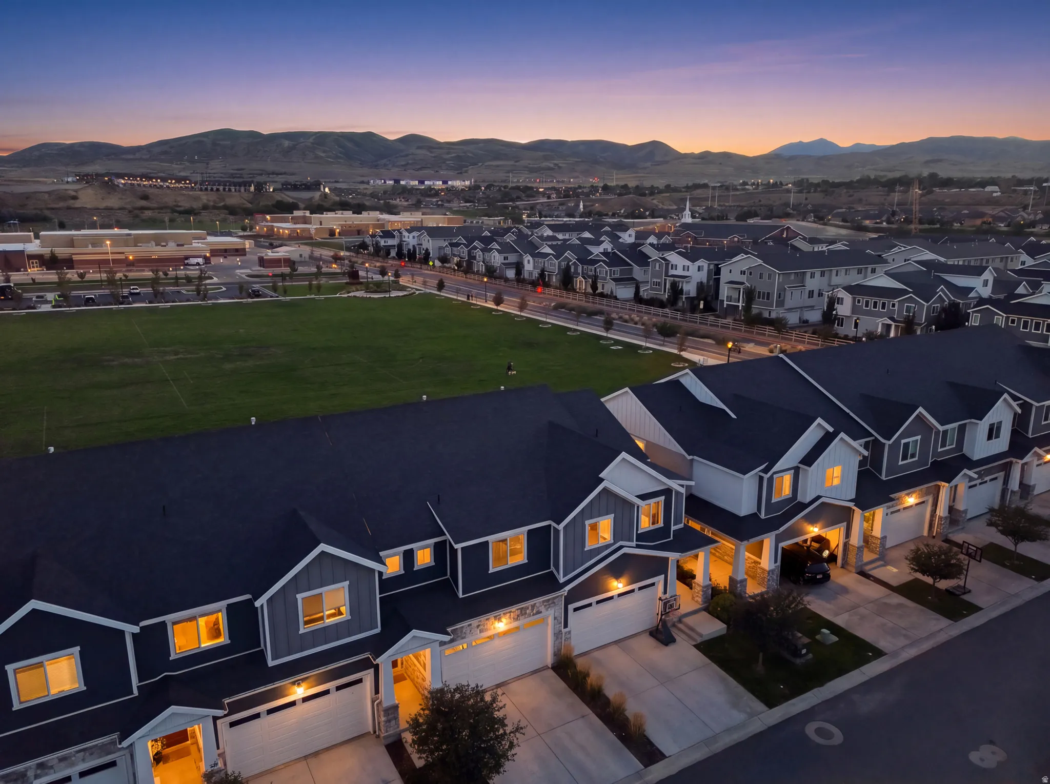 Townhome community with private garages, mountain scenery, and a grassy open space