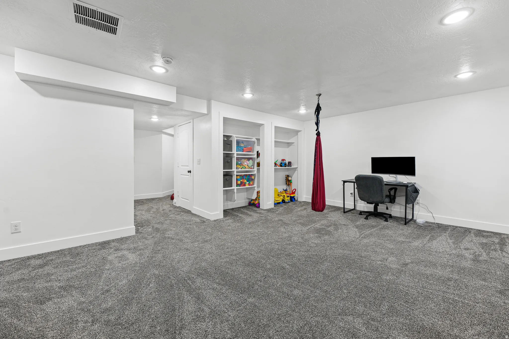 Recessed ceiling lighting, built-in shelving, plush carpet flooring, white walls, and white trim