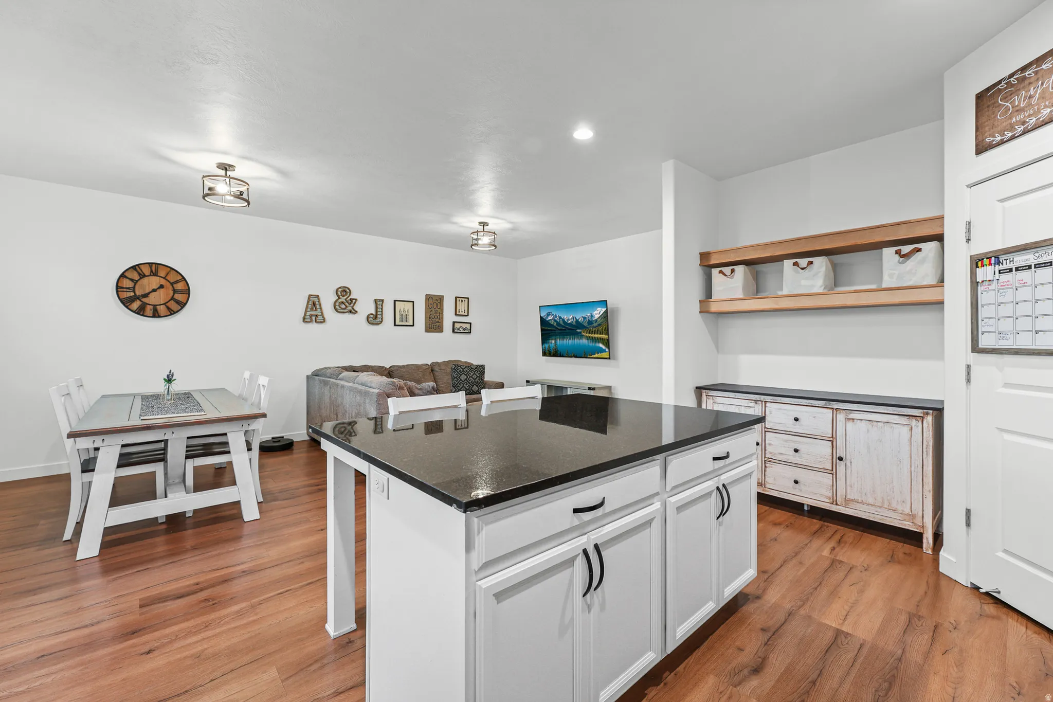 Central kitchen island with dark countertop and white cabinetry