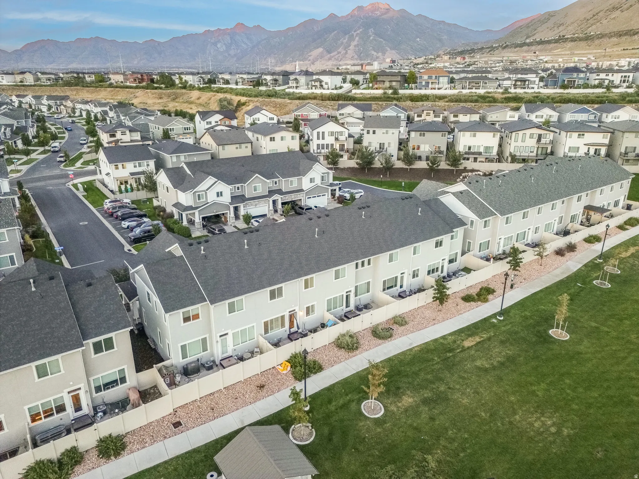 Townhome-style residences with light-colored siding and dark shingle roofing
