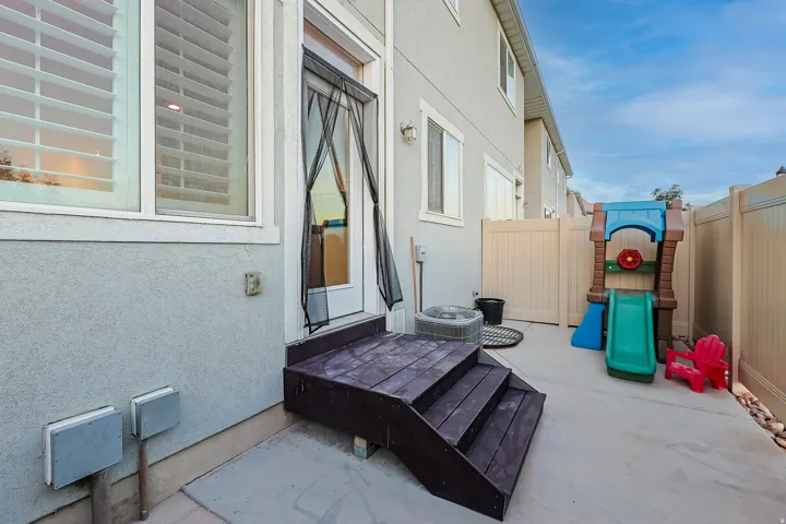 Paved patio area with multi-level wooden stairs and a privacy fence