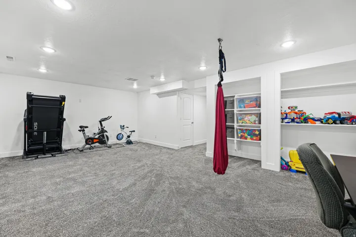 Spacious room featuring neutral carpeting, recessed lighting, and built-in shelving units