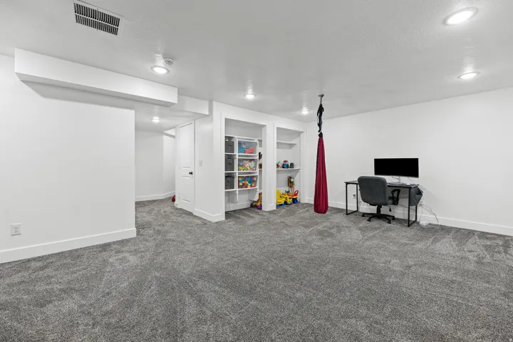 Recessed ceiling lighting, built-in shelving, plush carpet flooring, white walls, and white trim