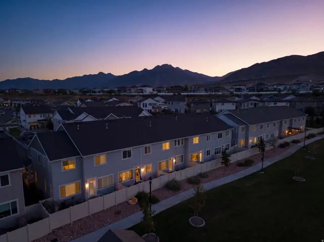 Townhome community with mountain scenery, individual fenced yards, and a paved walking path bordering a common green space