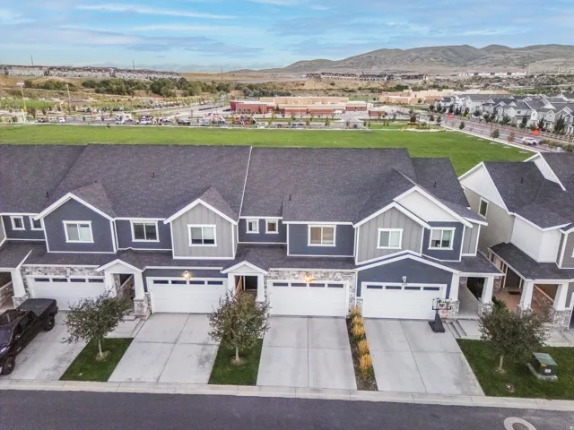 Townhome exterior with a dark shingle roof, gray siding, and white trim accents