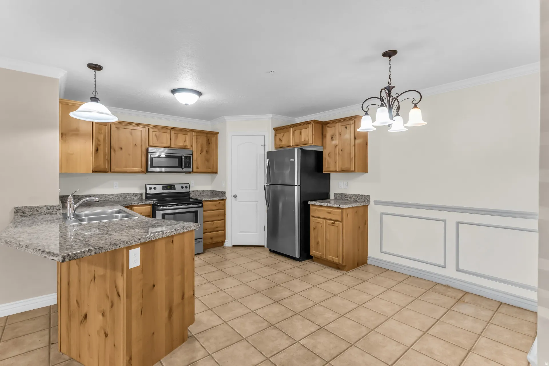 Kitchen featuring wood-finish cabinetry, stainless steel appliances, and granite-finish countertops
