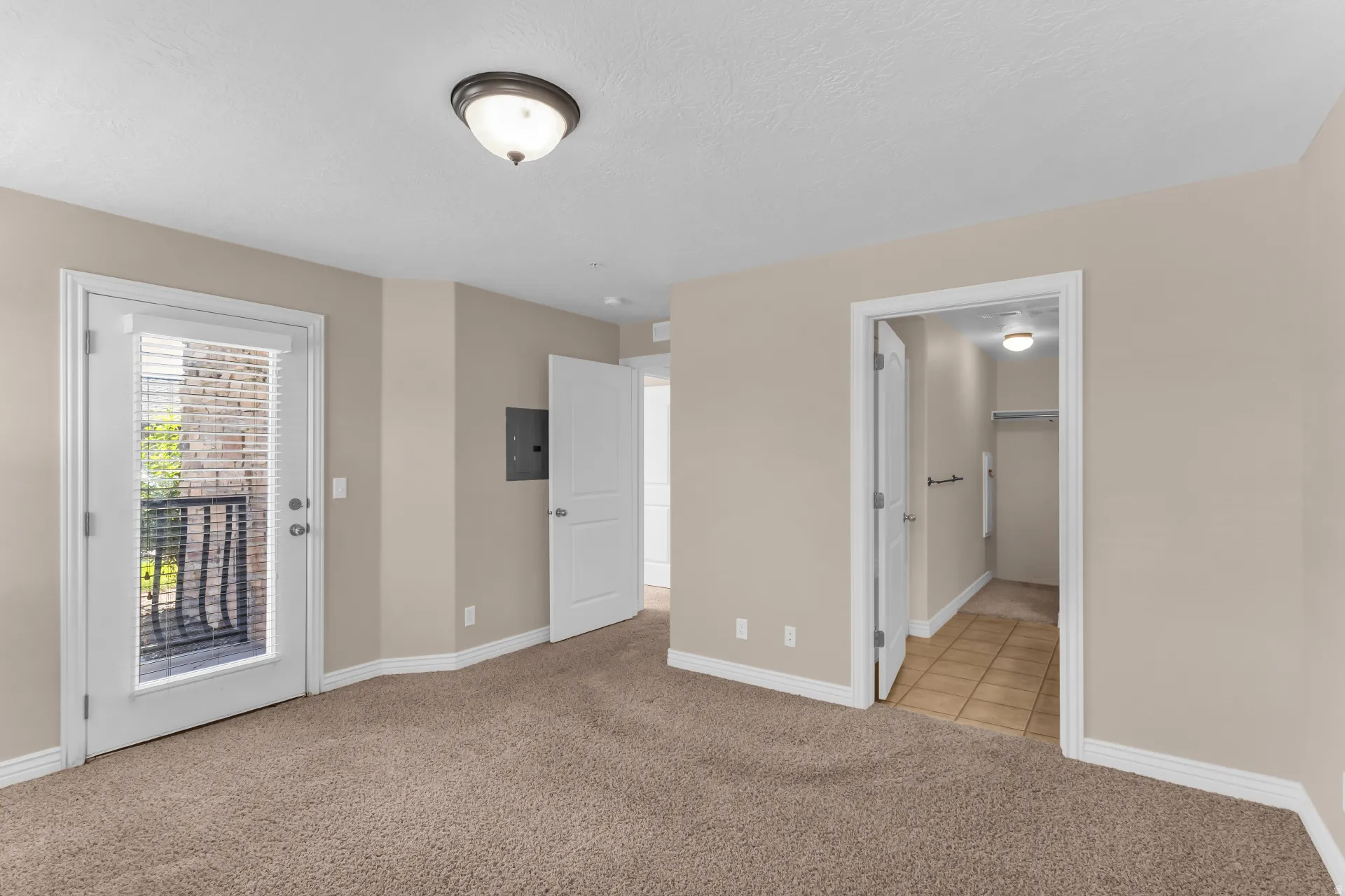 Neutral paint finishes throughout, carpeted flooring, and a flush-mount ceiling light fixture