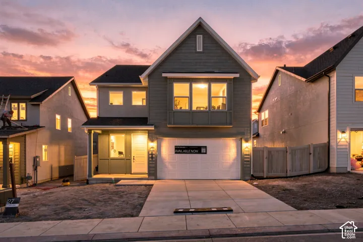 Two-story exterior featuring composite siding, a front-facing bay window, a covered porch entrance, and an attached two-car garage