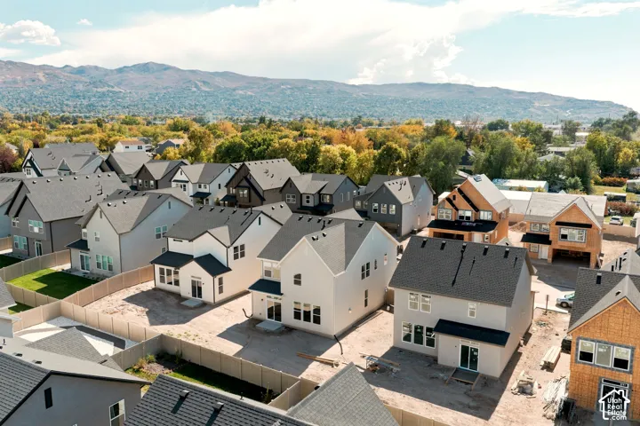 Aerial perspective of a multi-structure residential development featuring multi-level exteriors, asphalt shingle roofing, and mountain backdrop