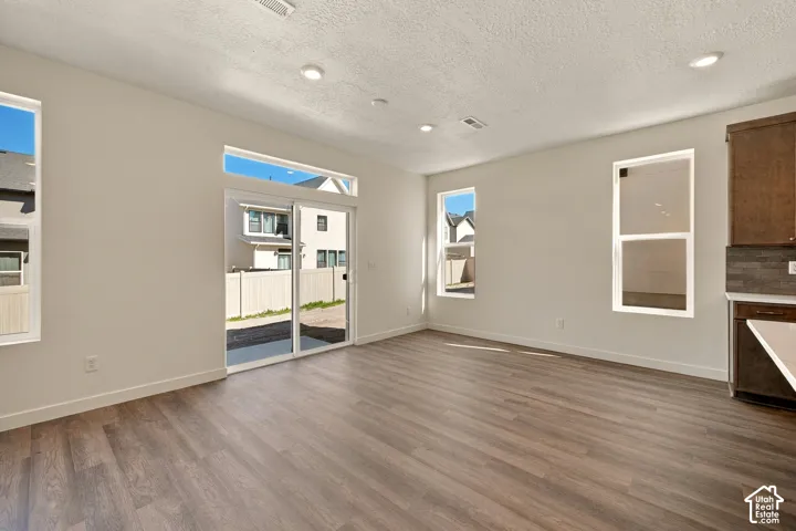 Open-concept interior featuring wood-finish flooring, recessed lighting, expansive windows with a transom, and sliding glass doors